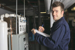 An HVAC technician inspects equipment with a smile.